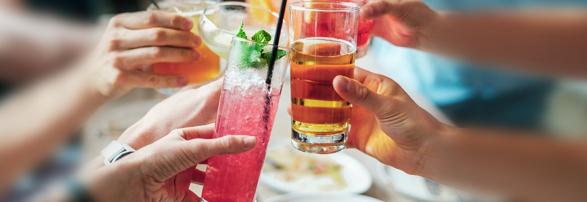 Ludzie wznosza toast szklankami z różnymi drinkami